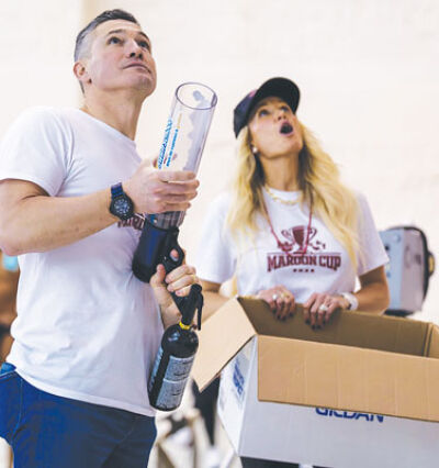  Goldfish Swimschool founders Chris and Jenny McCuiston launch T-shirts into the crowd at last year’s Maroon Cup. 