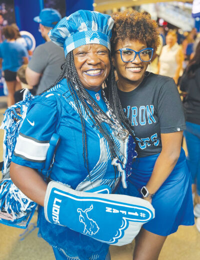  Jackson-Wright and Wright pose for a photo while at a Detroit Lions game. 
