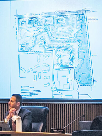  A map showing the pathway that developers plan to create can be seen as Mayor Justin Fischer listens to the developer’s presentation. 