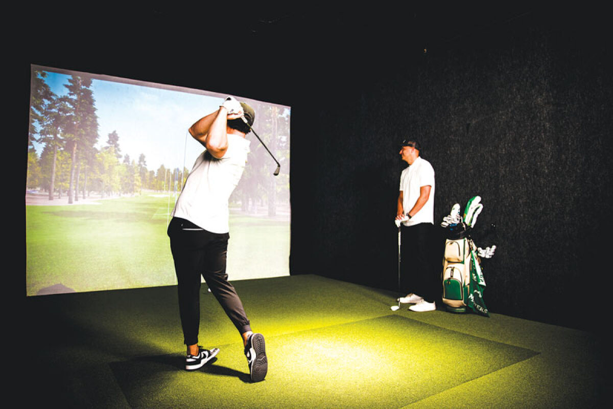  A pair look at the Back Nine sim screen to see the result of a shot from the virtual tee box. 