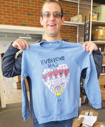  Sam Morris, 34, of West Bloomfield, displays a sweatshirt featuring his “Everyone Has Value” design and slogan, meant to promote the dignity of those with disabilities. 