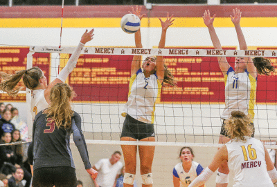  Bloomfield Hills Marian seniors Ava Sarafa, left, and Reagan Sass, right, go up for a block against Farmington Hills Mercy Sept. 28 at Mercy High School. 