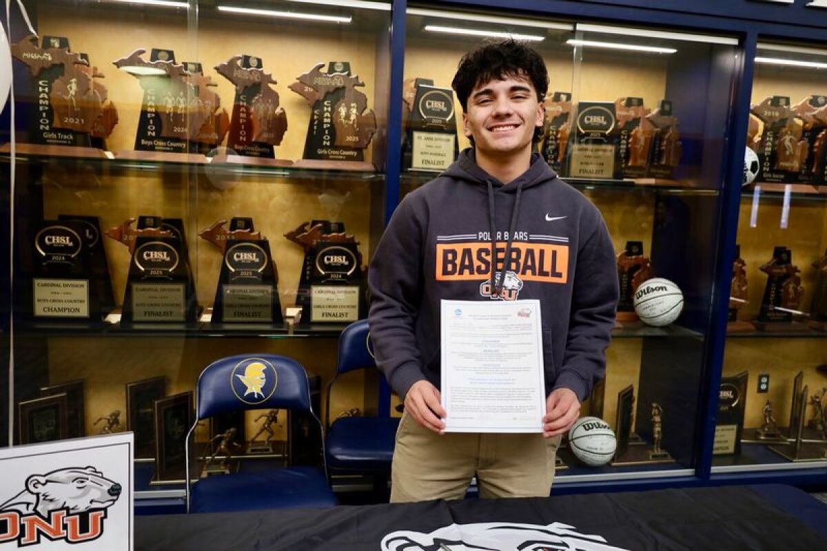  Nate Alba holds up his commitment letter to Ohio Northern University at Shrine Catholic High School on Feb 5. 