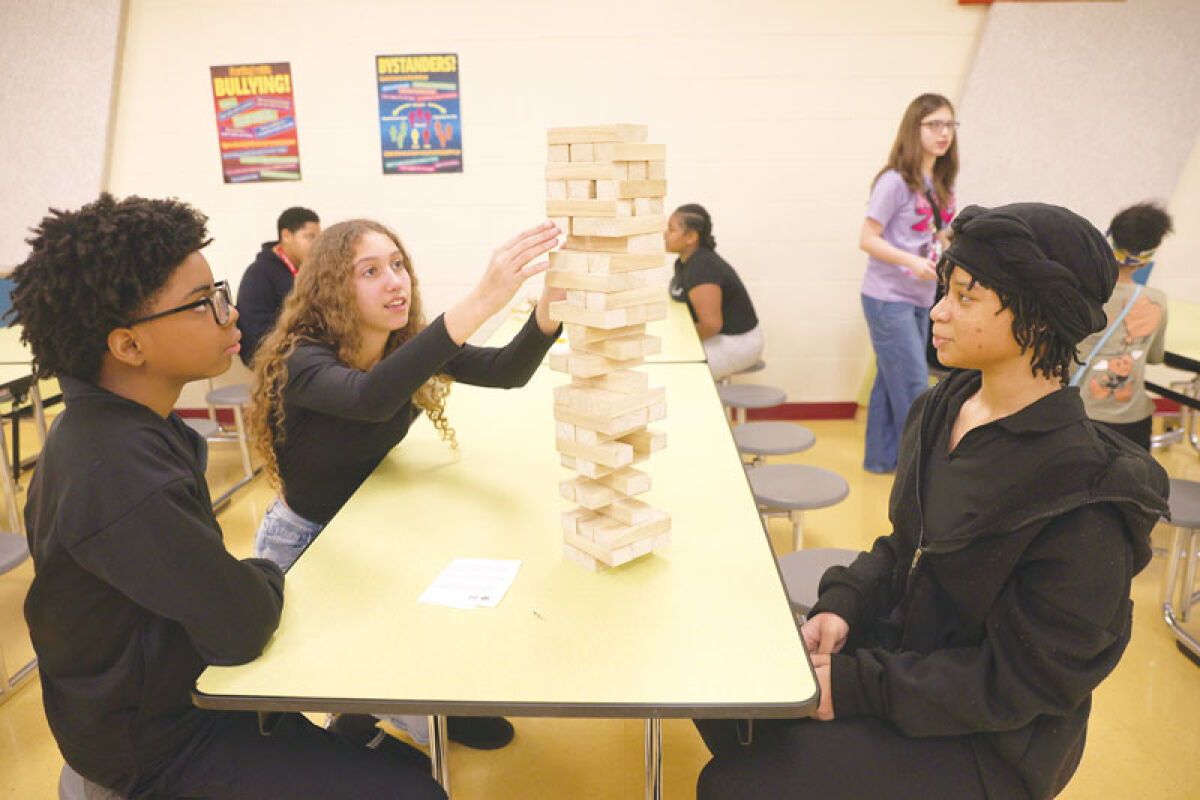  Seventh grader Miguel Edwards, 12; sixth grader Namyla Gupton, 11; and seventh grader Isabella Crosby 12, play Jenga during lunch time Feb. 18 at Lincoln Middle School. For the first time this year, the school became a no-phone zone.  