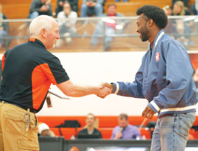  Olympian Freddie Crittenden receives his Hall of Fame plaque from Utica High School Principal Tim Youngblood. 