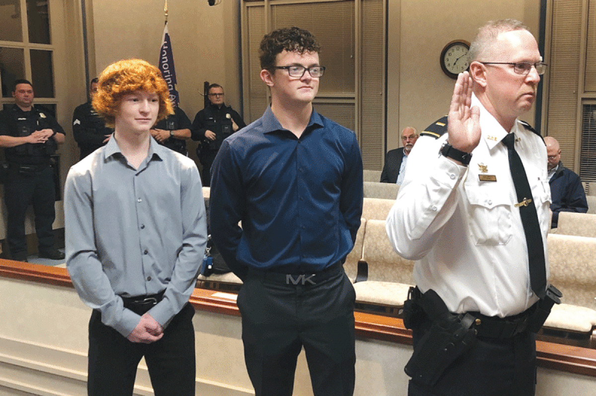  From left, Justin and Alex Spina look on as their father, Grosse Pointe Shores Public Safety Lt. Tony Spina, is sworn into his new rank during an Oct. 18 Shores City Council meeting. Several of Spina’s friends and fellow officers were also among those on hand. 