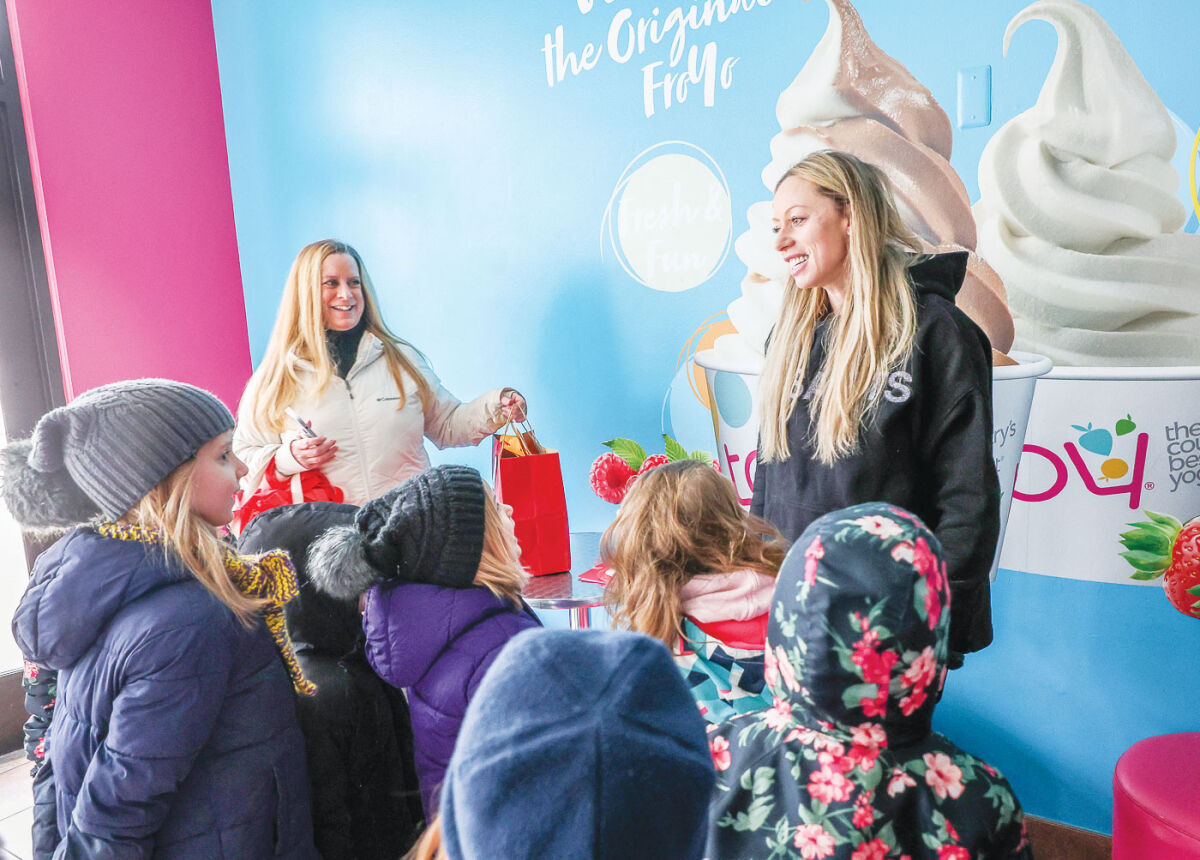  At right, Heather Ritts, owner of TCBY Frozen Yogurt, receives a handmade  valentine from Maire students Feb. 11 as Cindy Willcock, executive director of Main Street Grosse Pointe, left, looks on.  