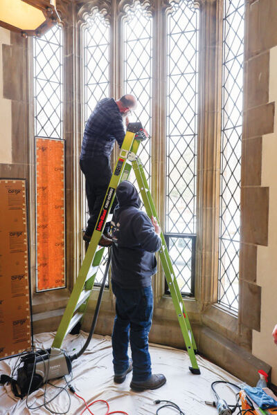  Josh Hanley, vice president of Omnibus Studios; Ruben Llano, project manager; and Matthew Eitniear, master craftsman, fitted custom frames with UV protection on the mansion’s mid staircase.  