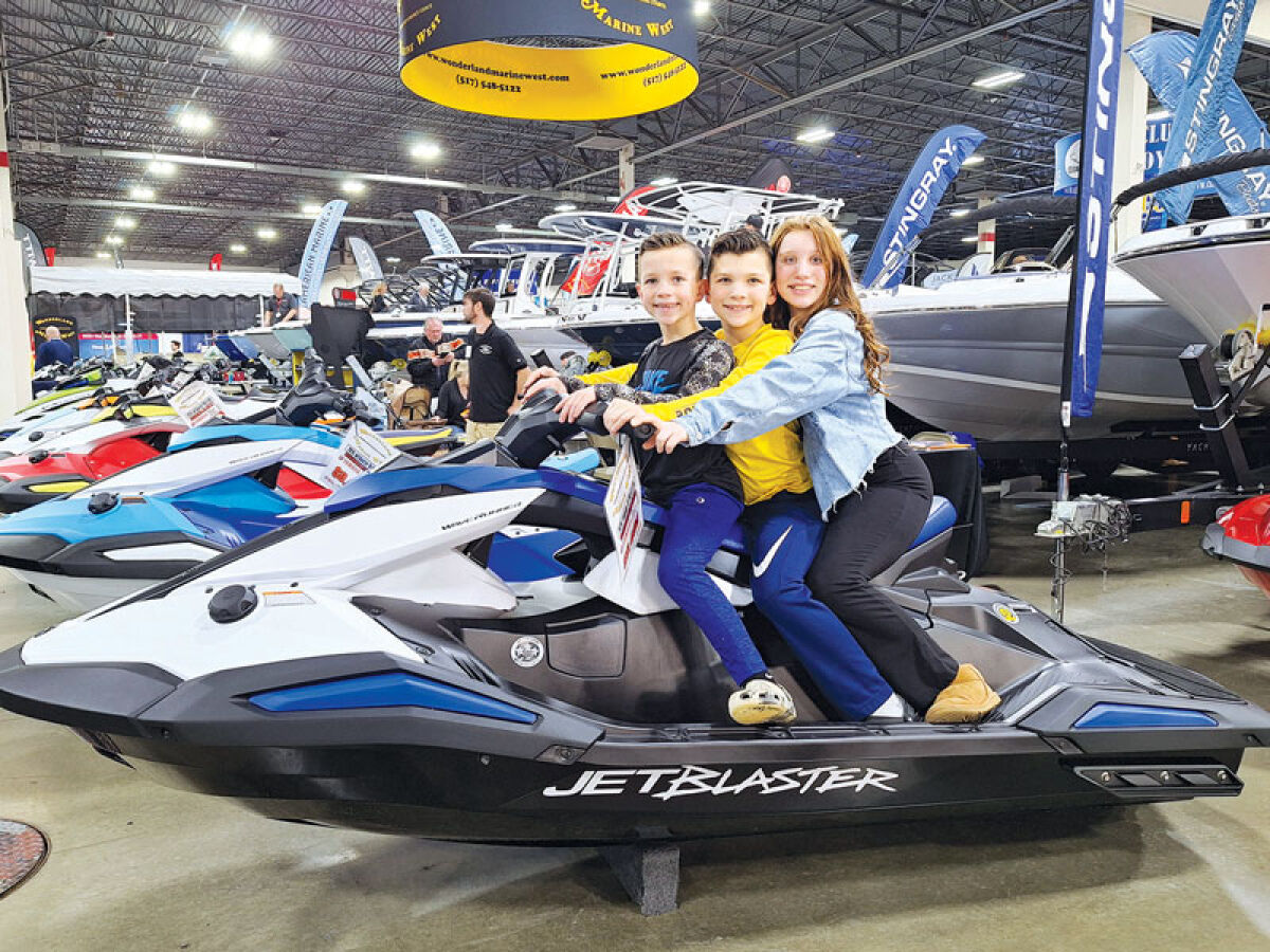  Siblings Gavin, 6; Levi, 8; and Violet Dovey, 11, of Clarkston, pose for a picture atop a personal watercraft as they try to convince their father to purchase it. 