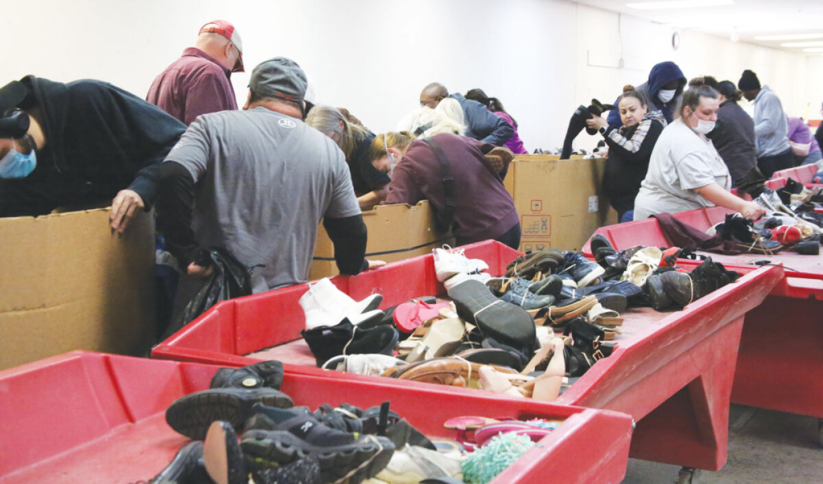  Customers at the Salvation Army By the Pound outlet store in Clinton Township rummage through boxes of donated shoes. The discarded shoes are placed on red rolling tables, which put the shoes back into circulation to be bought in bulk. 