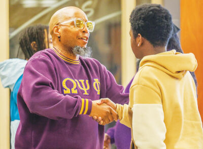  Howard Webb, Omega Academy-Macomb program director, left, demonstrates to a student how to properly give a handshake. BELOW: The Omega Psi Phi Fraternity’s Tau Mu Nu Chapter mentors boys every Tuesday at Lincoln Middle School in Warren in the group’s One Man Eager to Get Ahead Academy.  