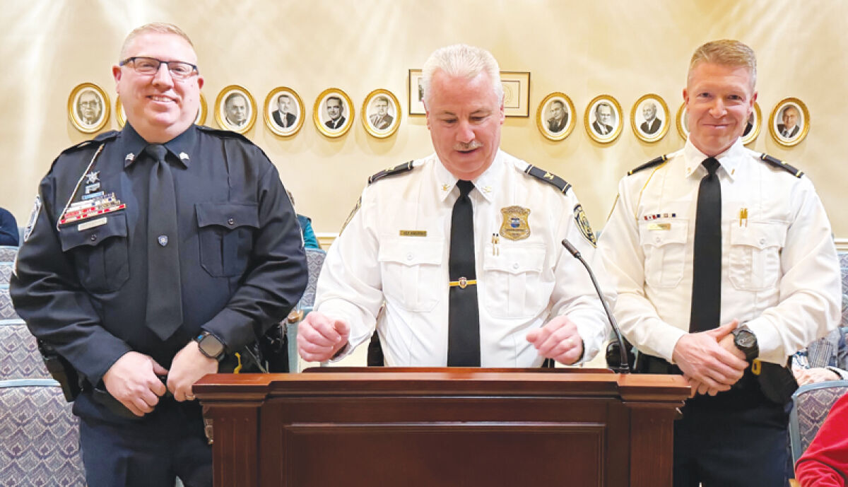  At left, Grosse Pointe Woods Public Safety Sgt. Dennis Walker and, at right, Lt. Brian Urban, listen as Public Safety Director John Kosanke, center, discusses their careers during a promotion ceremony March 2 at Woods City Hall. 