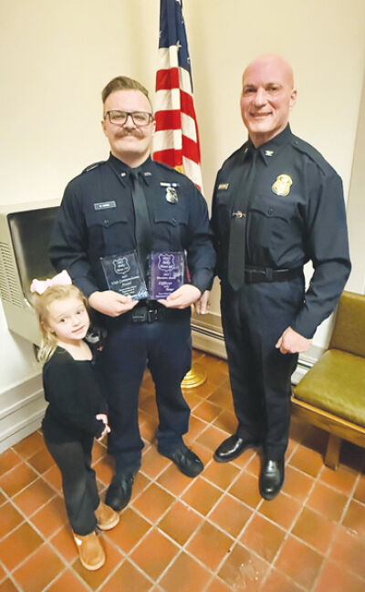  Accompanied by his daughter, Rozlyn Howe, 4, Grosse Pointe Shores public safety officer Billy Howe III stands with Public Safety Director Kenneth Werenski while holding a couple of his awards. Howe received the director’s award for 2025, the highest honor given by the department. 