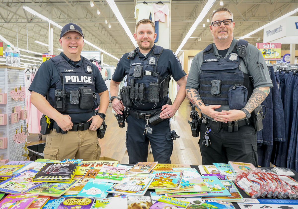  From left, Southfield police officer Tim Simon, Sgt. Larry Tomasino and Cpl. Steve Hendricks give out books and gunlocks to shoppers in the Southfield Meijer as part of the Southfield Police Department’s annual Badges & Books event on March 10. 