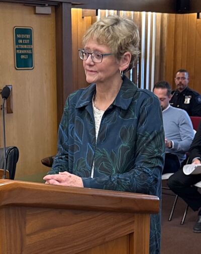 Grosse Pointe Farms Municipal Court Clerk Donna Emery Rabaut — who is being promoted to court administrator in April — listens as Mayor John Gillooly discusses her wide-ranging abilities during a March 9 City Council meeting. 