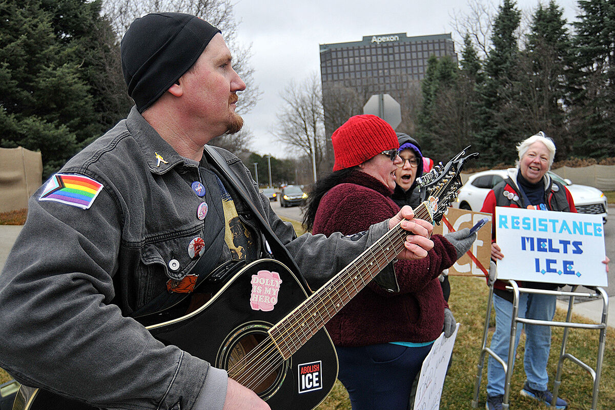  West Bloomfield resident Ben Pulver leads a sing-along and plays guitar at a protest near One Towne Square in Southfield on March 11. 