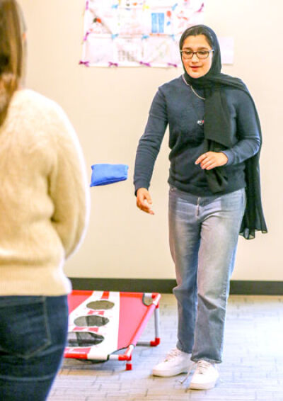  Rida Salim, student representative with the Novi Public Library board, plays cornhole at the library’s after-school Teen Space. 