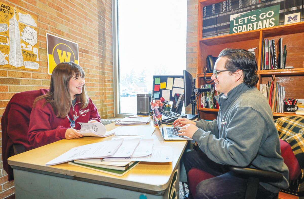  Fernando Monge, right, executive director for the Hazel Park Promise Zone, meets with Katrina “Kitty” Groeller, the  program’s post-secondary success coach, at Hazel Park High School.  