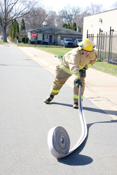  During the Golden Nozzle challenge March 14, Center Line High School  student Anthony Zehnpfenning sees how far he can toss a fire hose.  