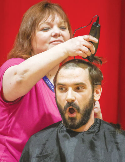  Susick Elementary School lunch supervisor and former cosmetologist Renee DenDooven gave Wilson a buzz haircut. Wilson volunteered to have his head shaved as an incentive for students to  pick up books and other reading materials during  March is Reading Month. 