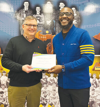 Dan Morin, CEO of Samaritas, presents a certificate of induction to the 2025 Coaches Who Care Hall of Fame Class to Redford Union basketball coach Randall Taylor. 