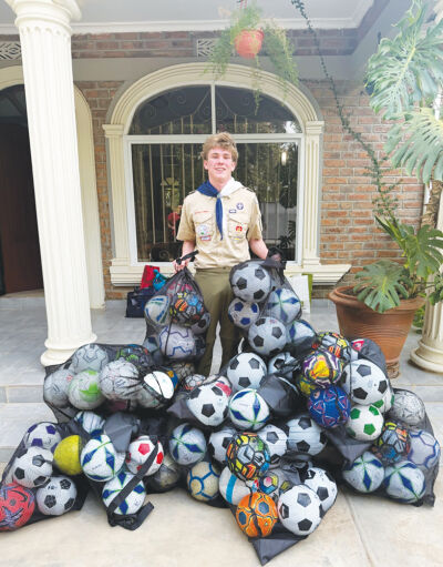  Eddie Minor with the soccer balls he collected to donate during his family’s trip to Tanzania.  