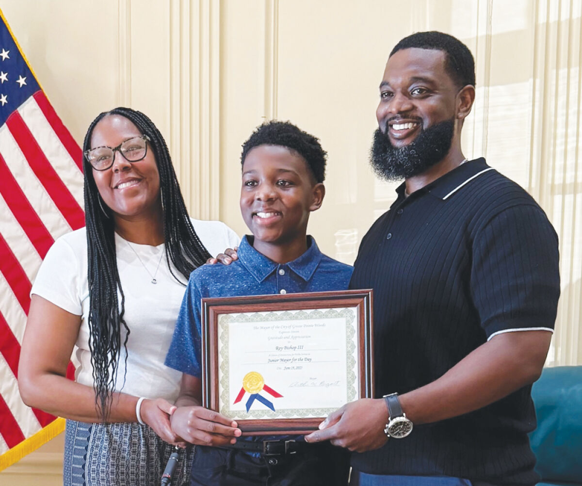  Grosse Pointe Woods student Roy Bishop III is flanked by his parents, Latoya Bishop and Roy Bishop II, as the youngest member of the Bishop family is recognized for serving as junior mayor for the day in the Woods last summer. His dad was just named the new superintendent for the Grosse Pointe Public School System. 