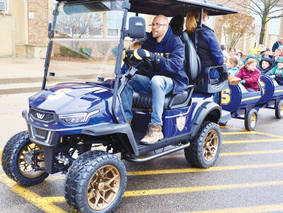  Shrine Grade School Principal Scott Wisniewski drives a train full of students behind a golf cart. 