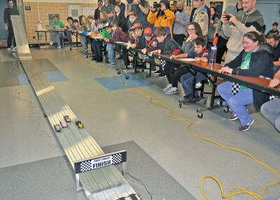  Cub Scouts, parents and friends gather inside Addams Elementary in Royal Oak to watch Pinewood Derby cars race to the finish line. 