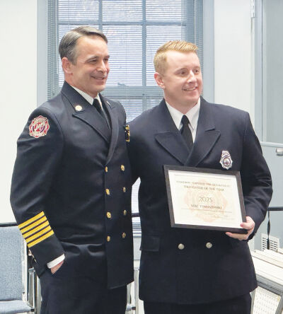  Harrison Township Fire Chief Dave Bostater presents the  Firefighter of the Year award to engineer Mac Tomaszewski at the Harrison Township Board of Trustees meeting on March 23.  
