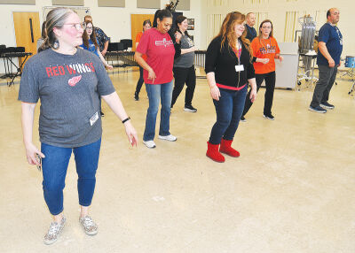  Fitzgerald Public Schools Director of Student Services administrative assistant Dionne Boza, left, leads a group of educators in a country line dance. 