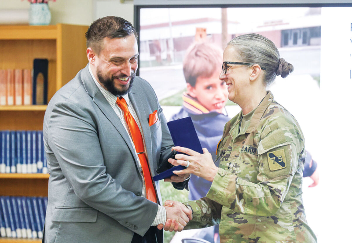   U.S. Army Maj. Gen. Michelle Link, right, presents Grissom Middle School Principal Justin Hauser with a special award when visiting the school March 26. The army general and the principal are cousins.  