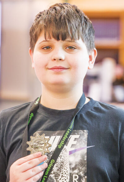  Grissom Middle School eighth grade student Noah Kosso holds up the military challenge coin U.S. Army Maj. Gen. Michelle Link gave to the students when she visited.  