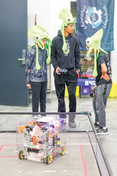  Novi Middle School students on the Cosmic Toads robotics team demonstrate their robot. 