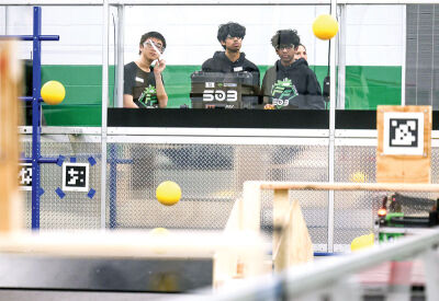  Members of Frog Force 503, the Novi High School robotics team, prepare a robot for a demonstration in the competition arena during the open house and grand opening. 