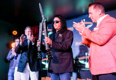  With guitar-styled scissors, rock ‘n’ roll icon Gene Simmons cuts the ribbon April 9 to officially open the new Rock & Brews in Royal Oak. Next to him are brothers Tony, left, and Danny Yezbick, who own the Royal Oak location.  