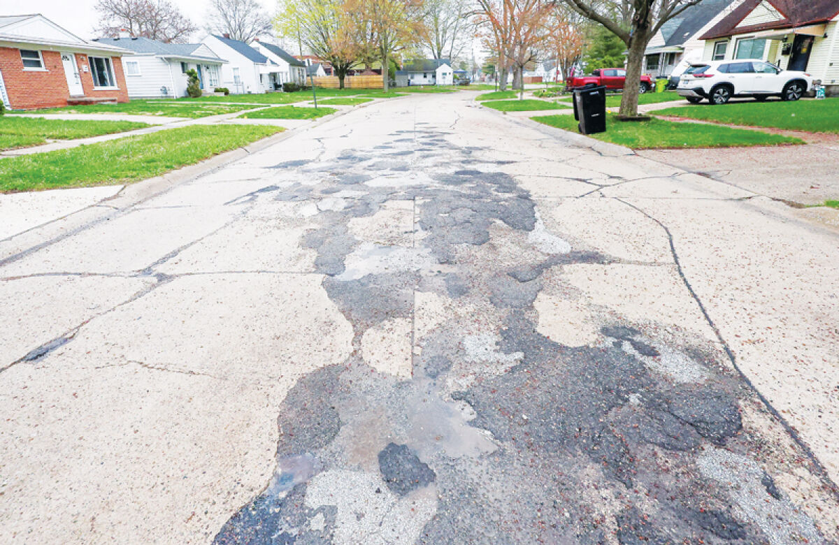  A view of deteriorating road conditions on University Drive in Madison Heights. An upcoming road millage proposal aims to repair residential roads and sewers.  