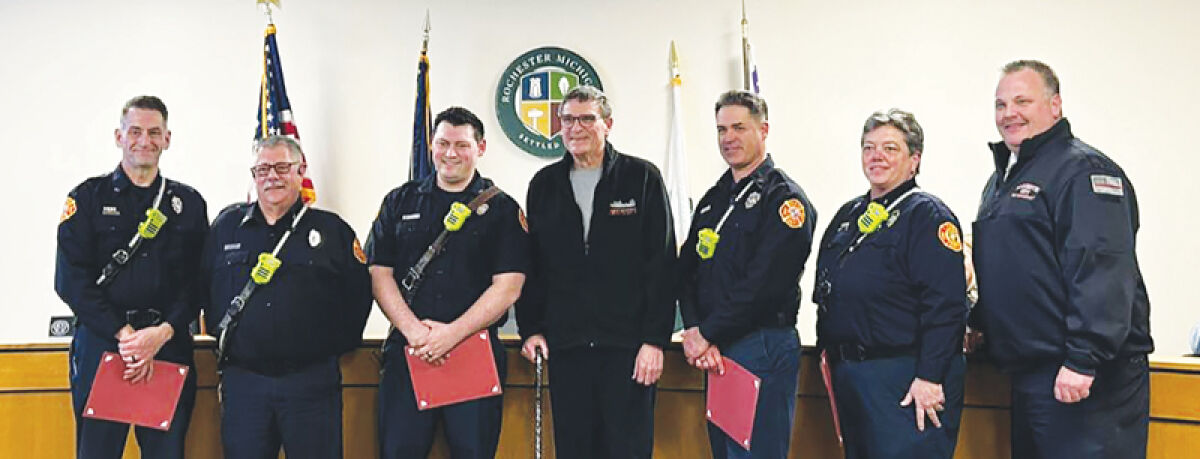  Rochester resident Brian York (center) poses for a photo with some of the Rochester Fire Department firefighters who saved his life. 