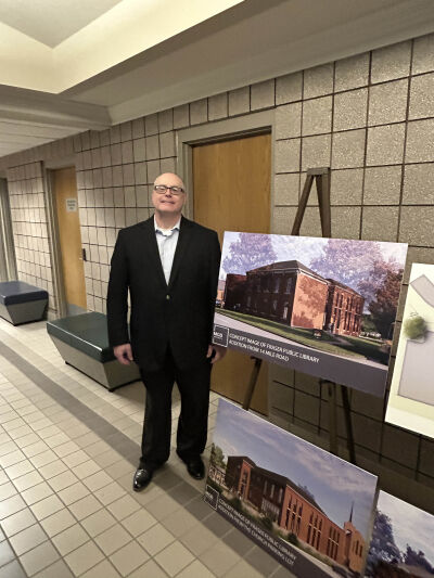  Jim Sutherland, president of the Fraser Library Board of Trustees, stands near renderings of the proposed new library building. 