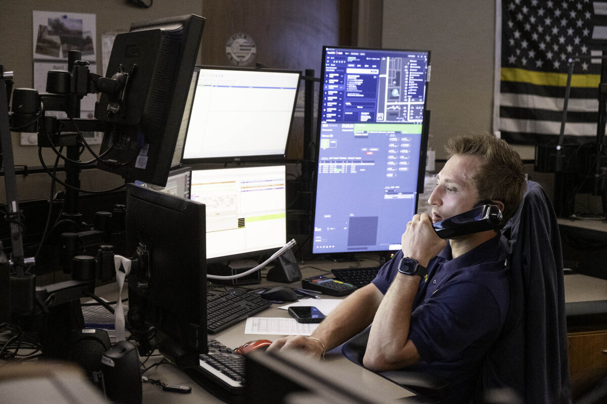 Austin Roman, Warren Police's newest dispatcher, looks over screens while answering fire calls in the department's dispatch center April 13. 