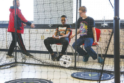  Students in the Youth Foundations in Flight program look on as they pilot drones in a netted-off area in the historic Mount Clemens High School building on April 7.  