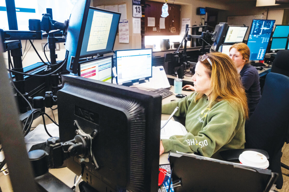  Warren Police dispatcher Linda DeVooght works on a computer while answering calls in the department’s dispatch center April 13. 