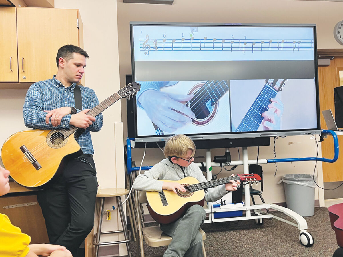  Carlson fifth grade student Zayden Czebieniak performs a solo version of “Ode to Joy” in Lead Guitar class April 13. “We’re trying to create a culture of music,” said Onur Alakavuklar, Lead Guitar regional director for Detroit, pictured, who teaches the program at Carlson. “There’s camaraderie with the music.”  