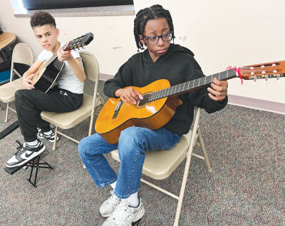  Carlson Elementary fifth graders Ayden Kellum, left, and Trenton Mitchell, warm up during Lead Guitar class April 13.  
