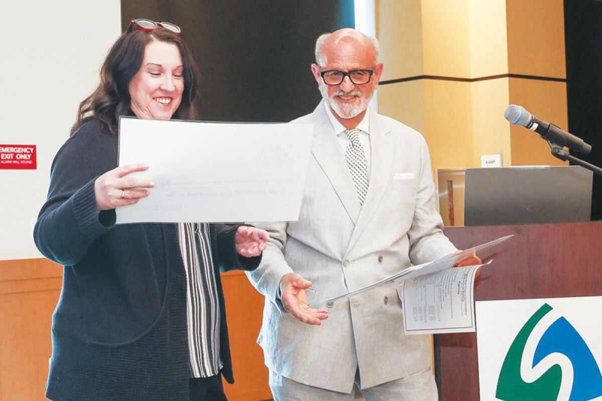  Sterling Heights Community Relations Director Melanie Davis, left, accepts an $8,500 grant from Sterling Heights Area Community Foundation Executive Director Karl Oskoian. The contribution helps support city events like the Sterlingfest Art & Music Fair, Cultural Exchange and Memorial Day Parade, among others. 