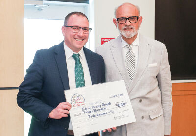  Sterling Heights Parks and Recreation Director Kyle Langlois, left, accepts a $40,000 contribution  from the Sterling Heights Area Community Foundation. The nonprofit organization’s executive  director, Karl Oskoian, made the presentation at an April 14 meeting.  