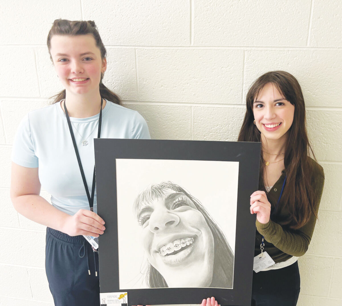  Shelby Junior High School ninth grader Ellie Miloian, left, and her friend and subject of her artwork, Natalie Wells, pose with Miloian’s art piece, “A Flattering Angle,” which earned a national silver medal in this year’s Scholastic Art & Writing Awards. 