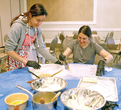  Alexandra Georgiadis, left, of Royal Oak, and Maria Luhring, of Troy, make Galaktoboureko. The popular Greek pastries are frozen until the week of the bake sale and then reheated. 