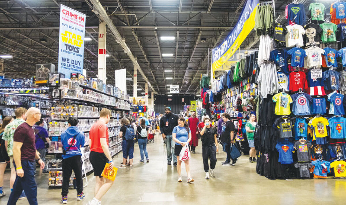  Attendees at Motor City Comic Con walk past booths full of collectibles and comic books during the first day of the event Friday, May 16, 2025, in Novi. 