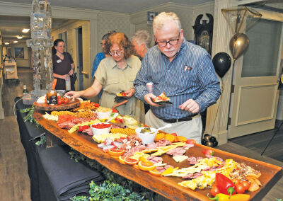  People serve themselves hors d’oeuvres in the reception hall at St. Anne’s Mead. 